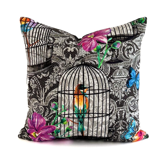 Decorative pillow with birdcage and floral design on a white background