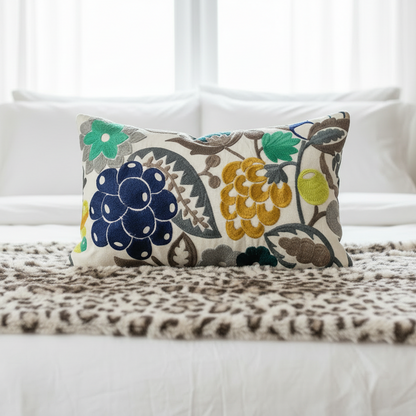 Decorative cushion with embroidered pattern on a bed with leopard print throw blanket