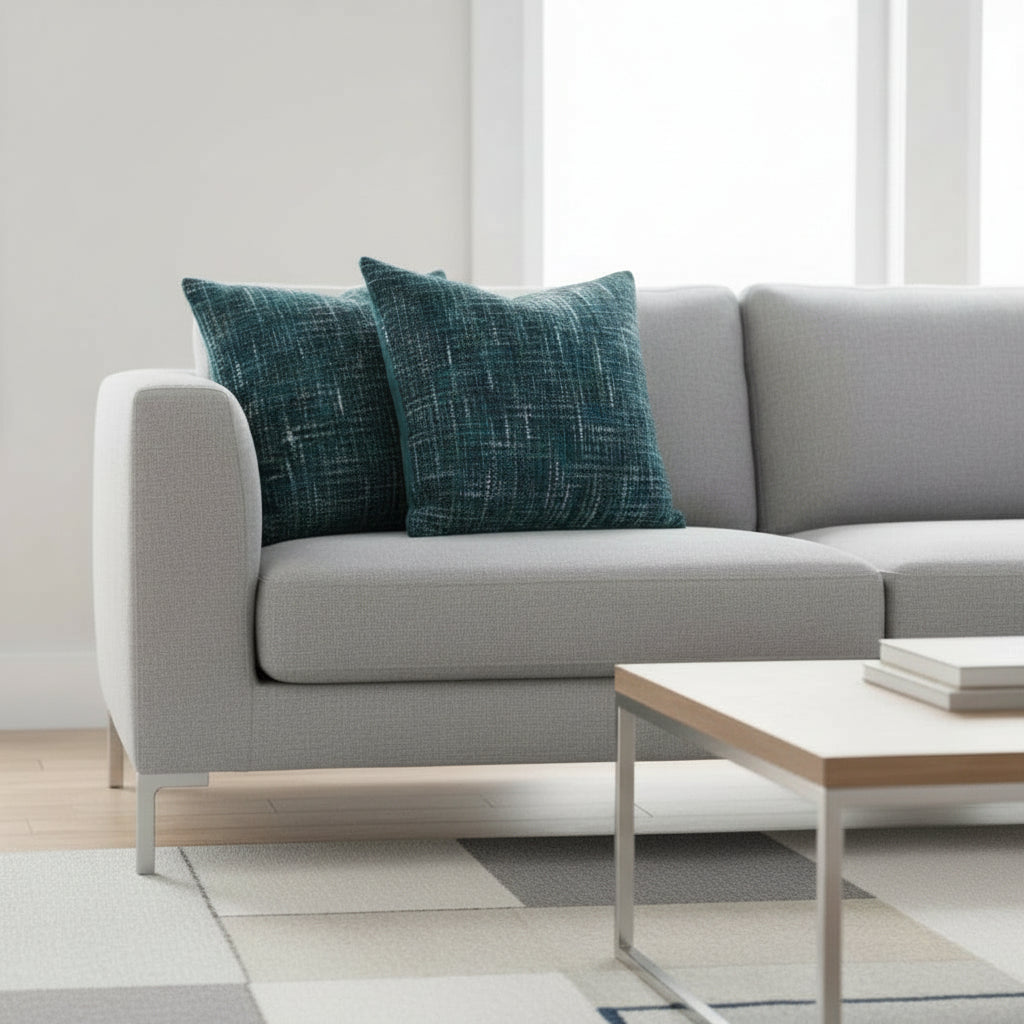Two textured cushions on neutral sofa with a modern coffee table and a modern floor rug.