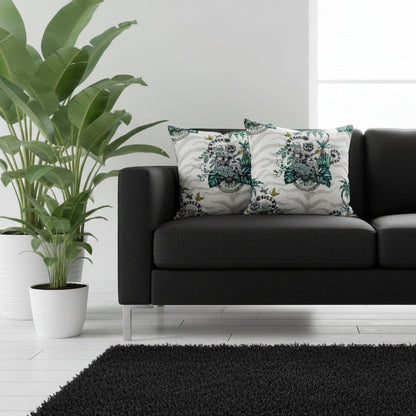 Black sofa with decorative pillows in a living room setting with plants and a rug.