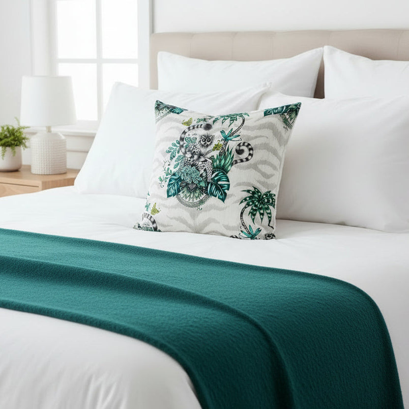 Decorative pillow with a lemur and tropical leaf design on a white background