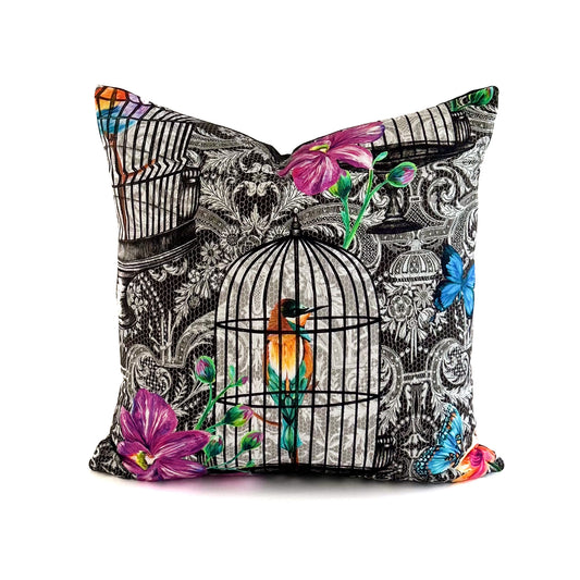 Decorative pillow with birdcage and floral design on a white background