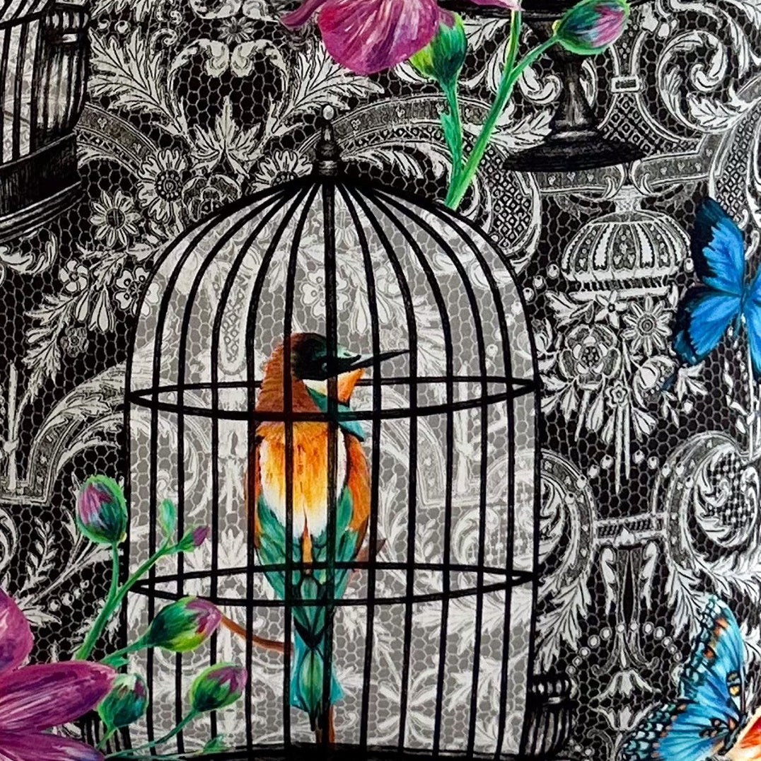 Decorative fabric with birdcage and floral design on a black and white lace patterned background