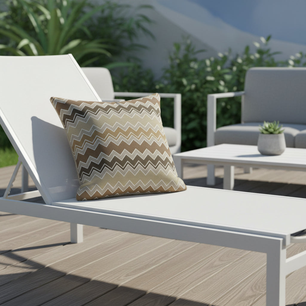 Decorative outdoor cushion with brown and beige zigzag pattern, sitting on a white outdoor lounger.