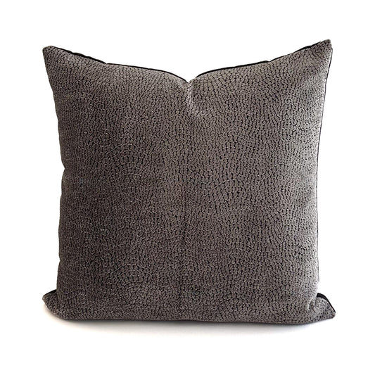 Textured grey cushion on a white background