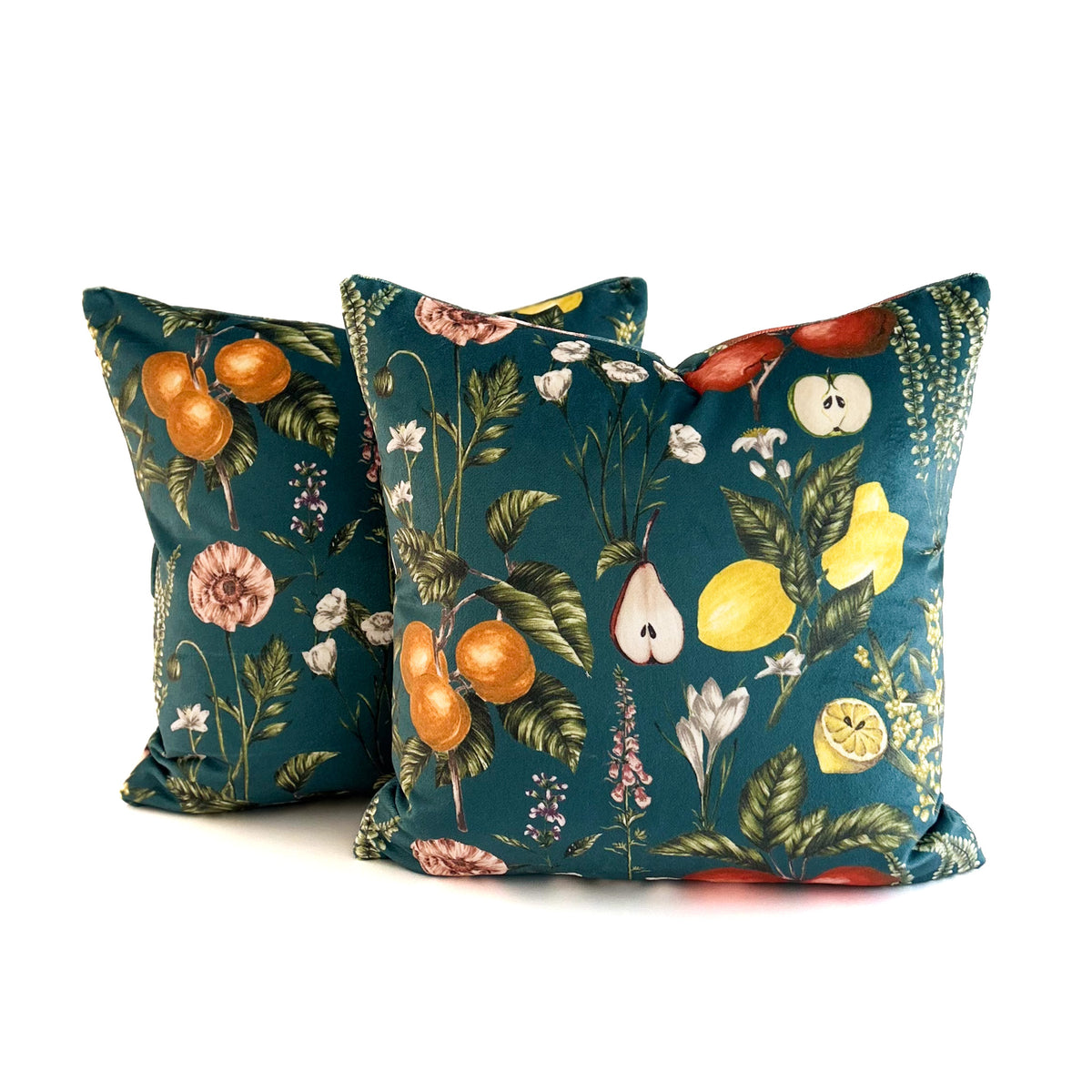 Two decorative cushions with fruit and floral patterns on a white background