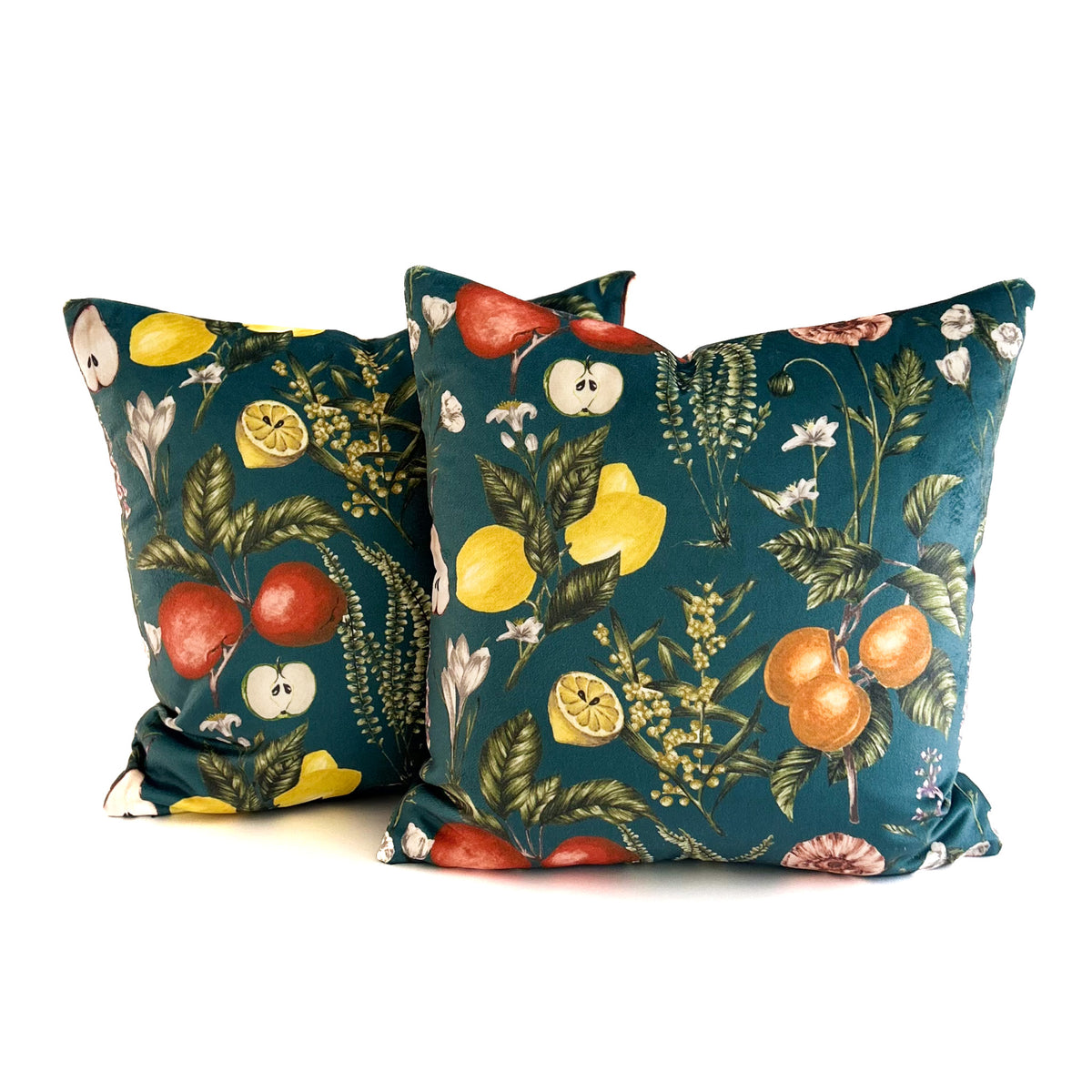 Two decorative cushions with fruit and floral pattern on a white background