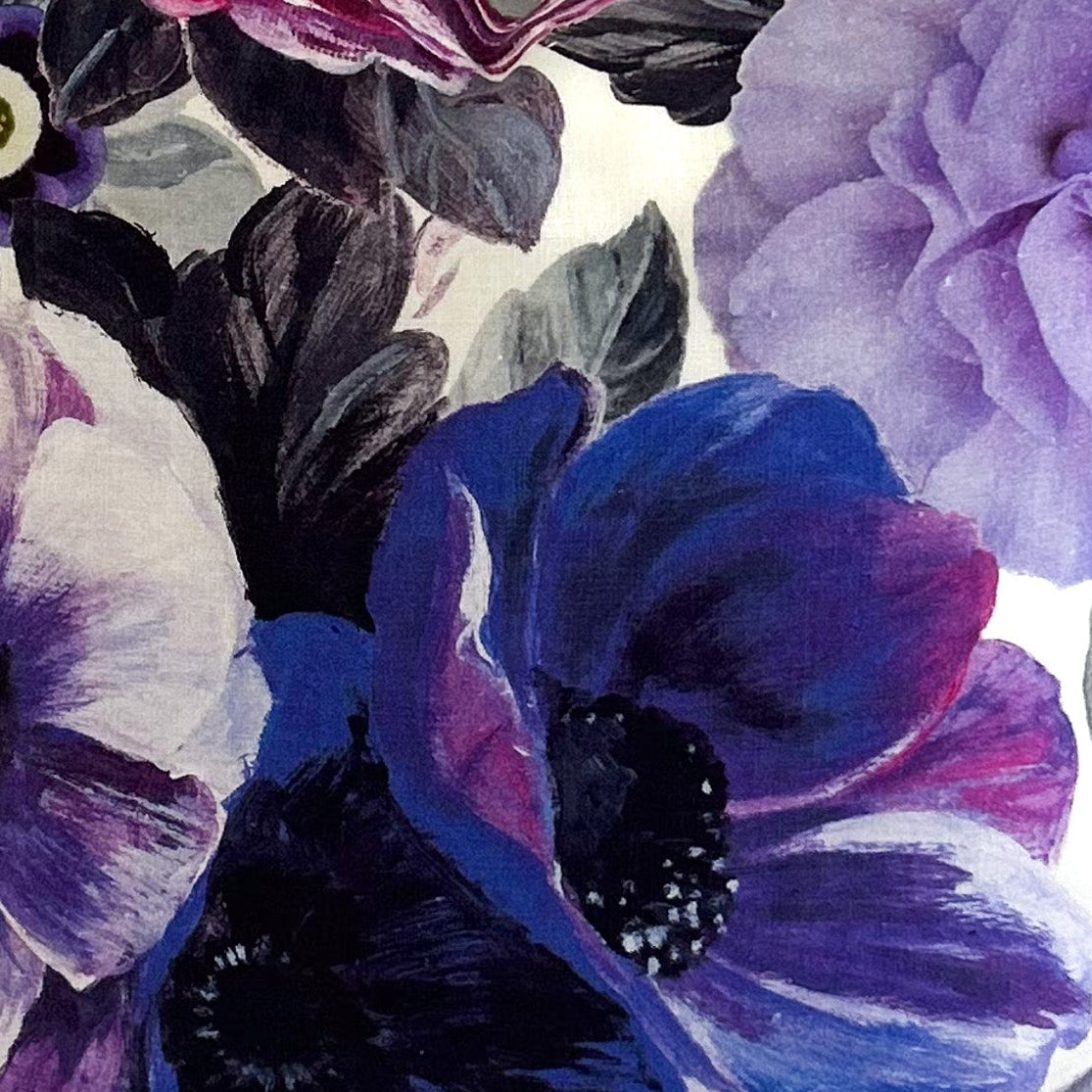 Floral-patterned fabric with purple and blue flowers on a white background