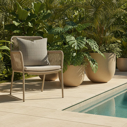 Outdoor chair with a textured cushion next to a pool, surrounded by potted plants