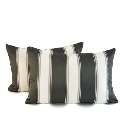 Two striped cushions with black, white, and grey colours on a white background