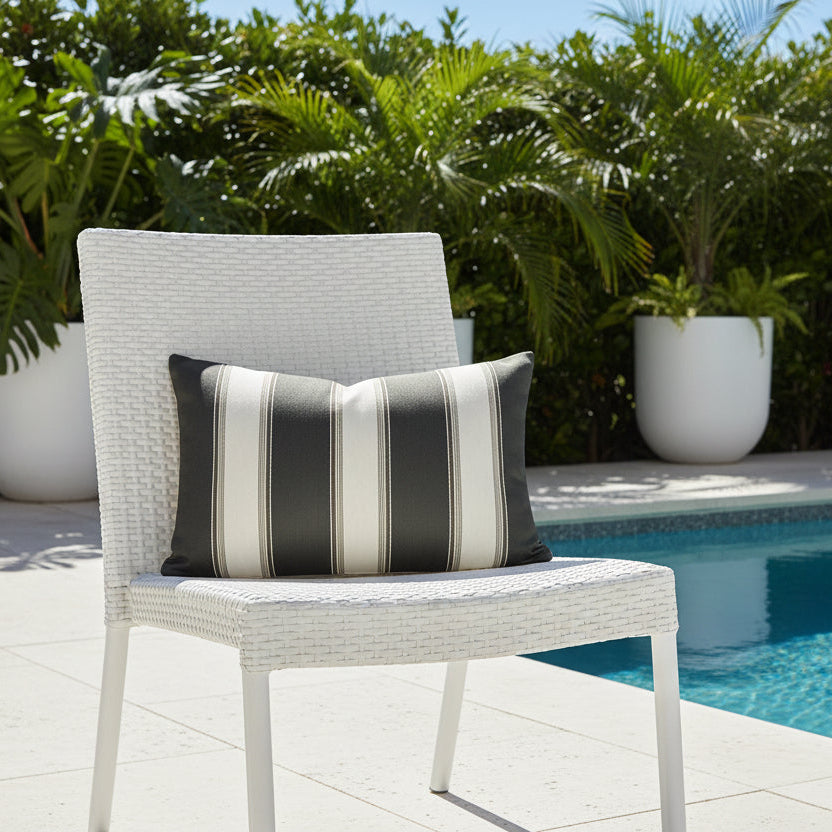 Chair with a striped cushion by a poolside with potted greenery