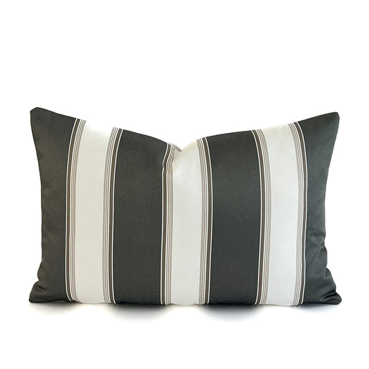Striped cushion with black, grey, and white colours on a white background
